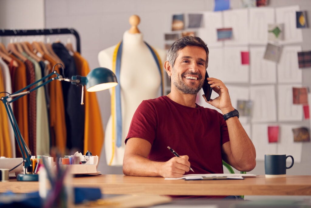 A small business owner smiling after receiving instant working capital loan approval over the phone.