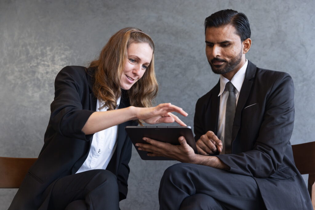 A business advisor and client reviewing financing options on a tablet.